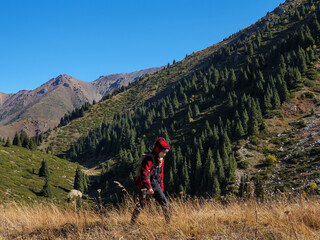 Fototapeta premium A boy walks high in the mountains. Hiking outdoors in the mountains