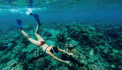Naklejka na ściany i meble fit woman wanderer snorkeling in sea during active summer holidays in touristic New Guinea
