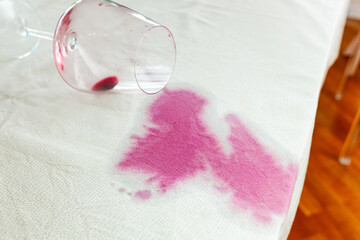 Spilled wineglass with a red spot on tablecloth - 662779352