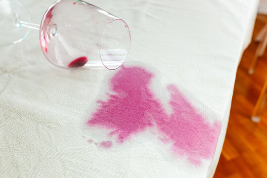 Spilled wineglass with a red spot on tablecloth