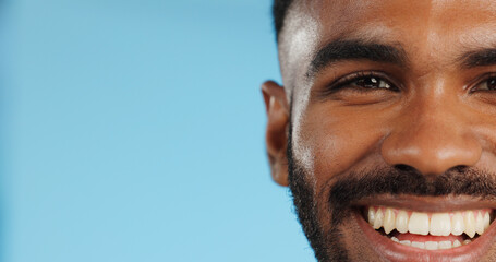 Half, face and black man with smile in studio, blue background and mockup space with happiness or advertising. Portrait, closeup and marketing for skincare, wellness or healthy dermatology care - obrazy, fototapety, plakaty