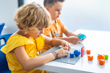 Robotics programming class. Preschool Children construct and code Robot. STEM education using...