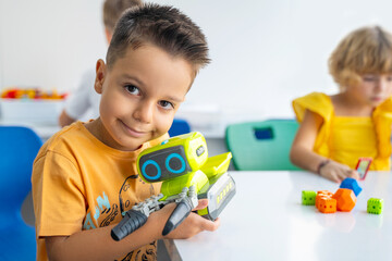 Robotics programming class. Preschool Children construct and code Robot. STEM education using...