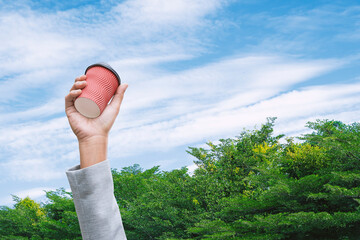 Businessman's hand raises coffee cup garbage waste for recycling. Eco-business recycle waste policy...