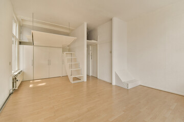 an empty room with white walls and wood flooring in the center of the room there is a mirror hanging on the wall