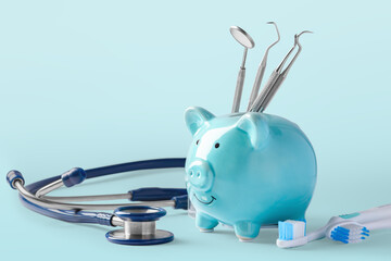 Dental cost concept, piggy bank with dentist instruments on blue background