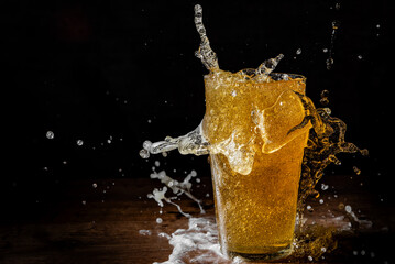 Freeze motion of pouring beer into glass on black background