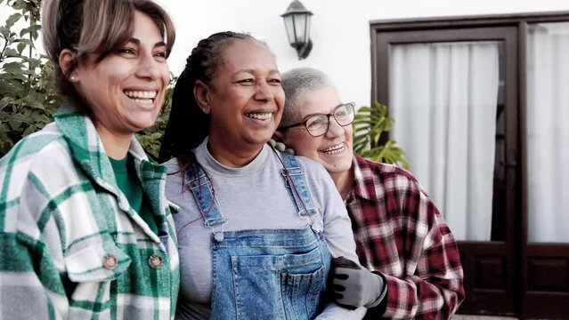 Happy multiracial senior women gardening at house garden