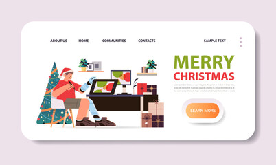 disabled man in santa claus hat graphic designer with replaced robotic leg and arm guy working on laptop people with disabilities