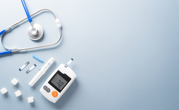 World Diabetes day concept ,14 November. Top view of blood glucose meter sets and stethoscope on pastel blue background.