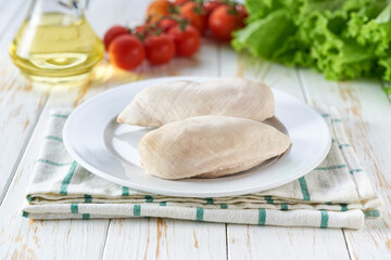 Boiled chicken filled with spices and herbs on a wooden table.