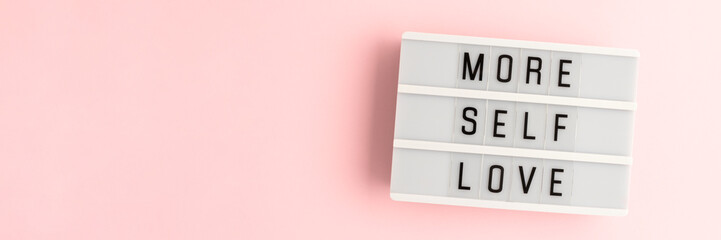 More self love. White lightbox with letters on a pink background. Banner with copy space.