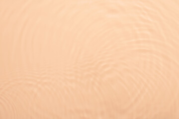 Water beige surface abstract background. Waves and ripples texture of cosmetic aqua moisturizer with bubbles.