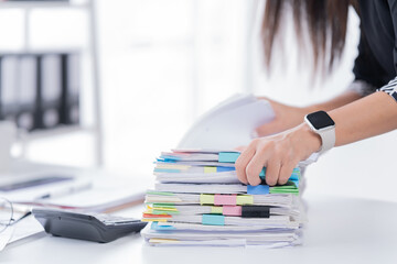 Business Documents concept : Employee woman hands working in Stacks paper files for searching and...