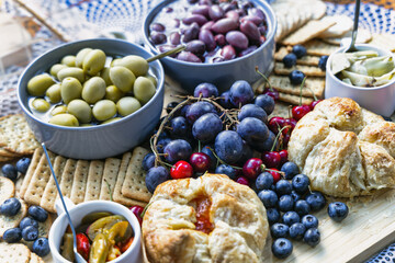 snacks on the table, grapes, olives, danish pastry, biscuits, atcha, berries , cherries, and various crunchies