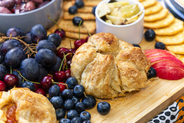 snacks on the table, grapes, olives, danish pastry, biscuits, atcha, berries , cherries, and various crunchies