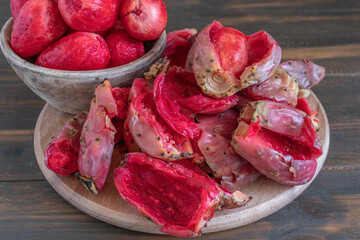 Peeled Opuntia fruits on wooden background.