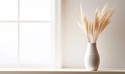 Tuinposter Decorative clay vase with pampas grass against window near white wall © Vodkaz