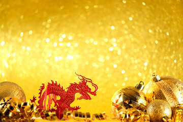 festive christmas decorations and asian red dragon close up on light golden shiny abstract...