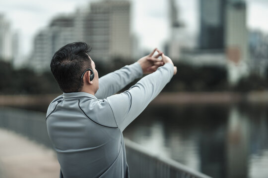 A Man Stretching His Muscle  In The City Center Park Before  Cardio Workout, Running.  Health And Lifestyle In Big City Life Concept.