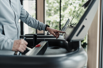 finger press botton running treadmill at gym for cardio. Fitness workout concept.
