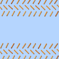 Pattern of cookie sticks isolated on blue background. Seamless pattern with copy space.