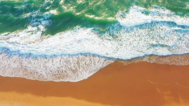 Aerial view beautiful tropical sandy empty beach and sea waves seen from above. Waves surf with turquoise water, sea shore, coastline. Panoramic view paradise beach
