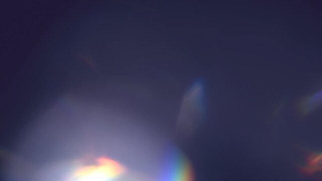 Lens Flare, Abstract Bokeh Lights Moving. Leaking Reflection of a Glass, Crystal, Defocused Shining Colorful rainbow Light Leaks, Rays on Black Background. Lense. Slow motion