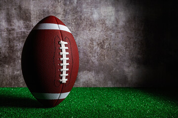 Standing american football ball over grass