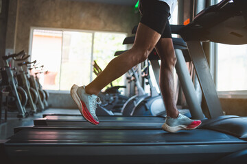 Close up of feet, sportman runner running on treadmill in fitness club. Cardio workout. Healthy lifestyle, guy training in gym. Sport running concept