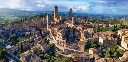 Foto auf Glas San Gimignano - one of the most beautiful medieval towns in Tuscany, Italy. aerial drone view of towers . Unesco heritage site. © Freesurf