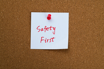 Safety first sticky note on corkboard