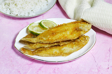 homemade fried fish lemon sole with rice in white plate on grunge pink background