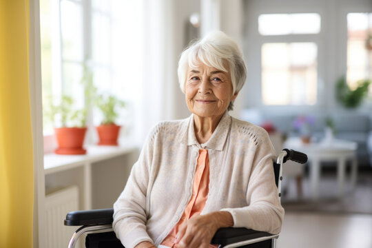 femme &acirc;g&eacute;e aux cheveux blancs assise dans un fauteuil roulant, souriante et heureuse 