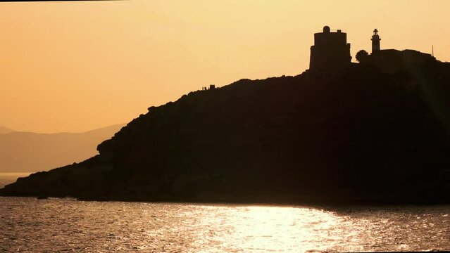 backlight image of a lighthouse on the cliff during the golden hour