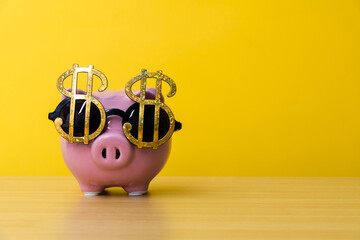 Piggy bank wears glasses with dollar sign