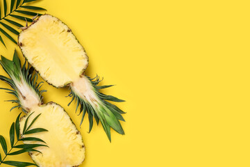 Halves of ripe pineapple and green leaves on yellow background, flat lay. Space for text - obrazy, fototapety, plakaty