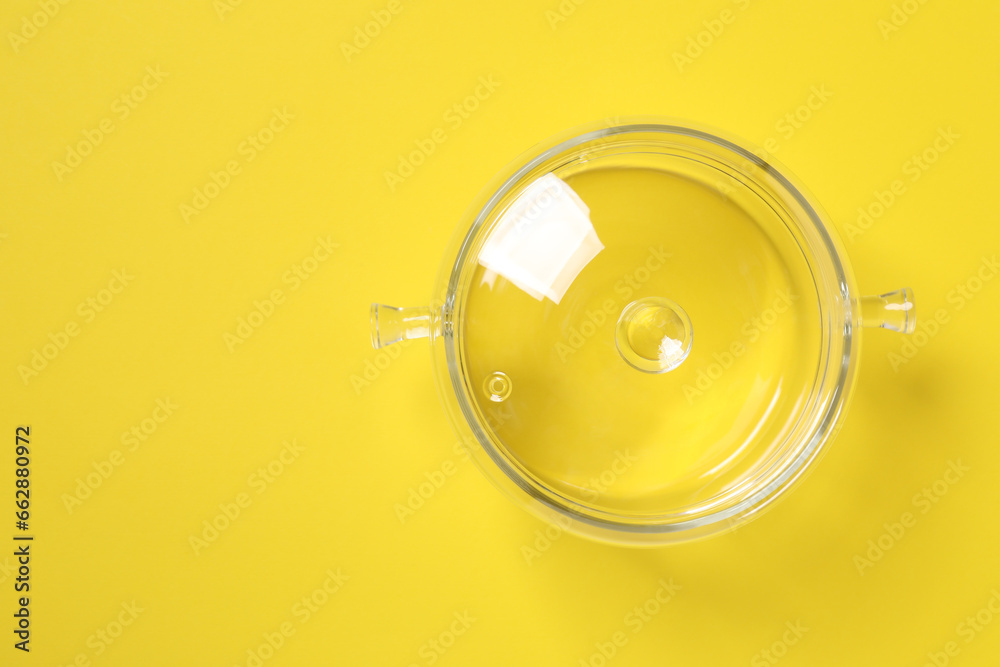Wall mural Glass pot with lid on yellow background, top view. Space for text - Wall murals