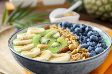 Tasty smoothie bowl with fresh fruits and oatmeal on table, closeup