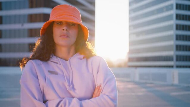 Cool fashionable black mixed race woman vlogger listening Macarena music. Trendy black girl dances, recording videostream video for tiktok at city street. Creating dancing video using social media app
