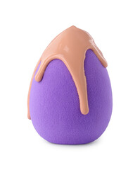Purple makeup sponge with skin foundation isolated on white