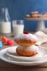 Hanukkah donuts with jelly and powdered sugar on wooden table, closeup