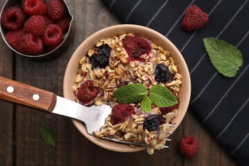 Tasty baked oatmeal with berries served on wooden table, flat lay