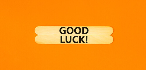 Good luck symbol. Concept words Good luck on wooden stick. Beautiful orange table orange background. Business, motivational good luck concept. Copy space.