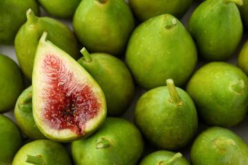 Cut and whole fresh green figs as background, top view