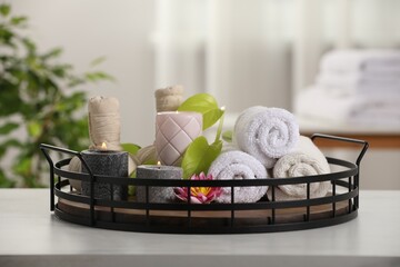 Composition with different spa products and burning candles on white table indoors