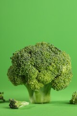 Fresh raw broccoli on light green background