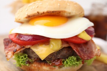 Delicious burger with fried egg on table, closeup