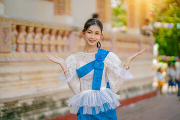 Portrait of Asian women with khmer traditional dress stand in front of pagoda with beautiful art...