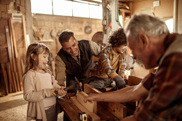 Young future carpenters learning the ways of their elders in a wood shop